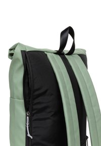 Zaino con corpo in nylon nero e dettagli verde chiaro, comprese le cinghie. Include una tasca con zip laterale e una maniglia superiore per il trasporto.