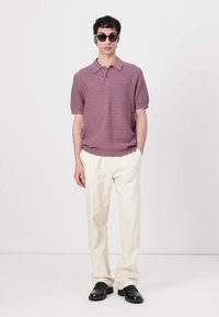 Purple textured polo shirt with a collar, paired with cream trousers and black shoes, featuring a slim fit and short sleeves.
