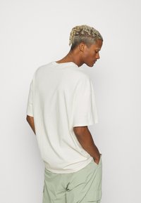 Puma CLASSICS BOXY TEE - T-Shirt print - off-white