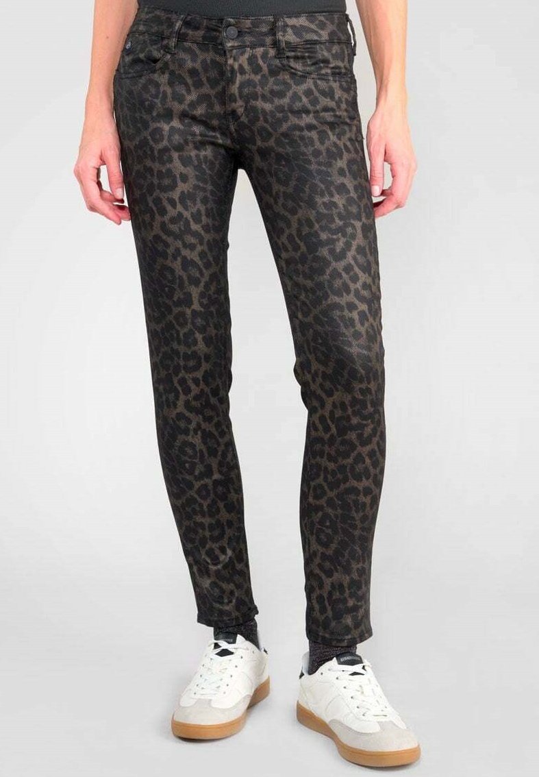 Svarta och bruna leopardmönstrade skinny jeans med fem fickor, med medelhög midja och ankel-längd, i kombination med vita sneakers.