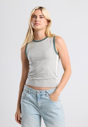 Gray sleeveless top with a crew neck, teal trim, and a fitted design. Paired with light blue high-waisted jeans.