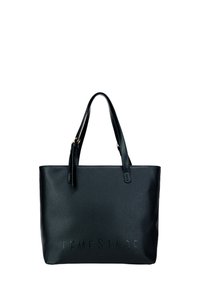 Zwarte leren tote bag met twee handvatten, geperst "FEMESTAGE" logo aan de voorkant, textured oppervlak, rechthoekige vorm, minimalistisch ontwerp.