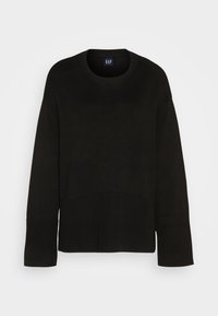 Svart stickad tröja med rund halsringning, vida ärmar och ribbat nederkant. Har ett strukturerat mönster och en logotag vid halsen.