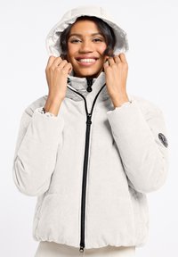 Gequiltede, lichtgrijze corduroy jas met een capuchon, voorzien van een zwarte ritssluiting en elastische manchetten. Logo-opdruk op de linkermouw.