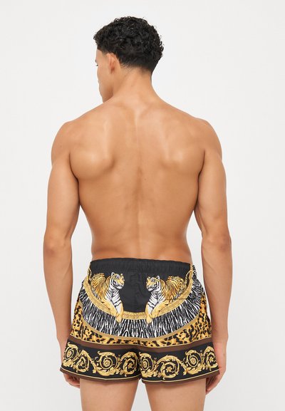 Melnas peldbikses ar leoparda rakstu, zeltītām detaļām un tīģera grafiku. Biksēm ir elastīga josta komfortam.