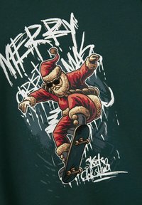 Grafica rossa e marrone di Babbo Natale che pattina su uno skateboard, indossando occhiali da sole, su uno sfondo verde scuro con testo in stile graffiti bianco.