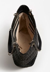 Sac à main noir matelassé avec poignées en chaîne dorée, doublure intérieure beige avec le logo "Guess" et plusieurs compartiments zippés à l'intérieur.
