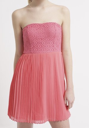 Robe rose sans bretelles avec un corsage en dentelle et une jupe en chiffon plissée, présentant une texture douce, un corsage ajusté et des éléments de conception fluides.