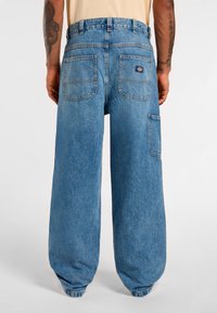 Light blue denim wide-leg pants featuring a high waist, two back pockets, and a side pocket. The fabric has a soft, textured finish.