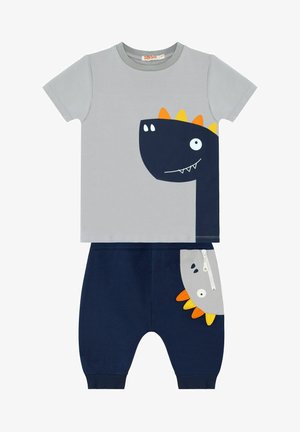 Szary T-shirt z krótkim rękawem z grafika dinozaura w kolorze granatowym; pasujące granatowe spodnie z szarą kieszenią i kolorowymi akcentami dinozaurów. Tkanina z mieszanki bawełny.