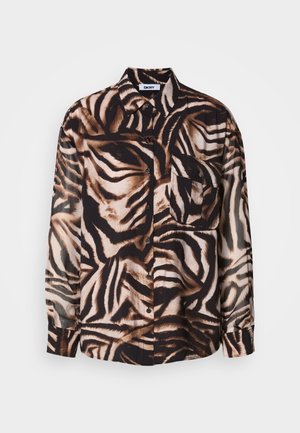 Camisa de manga larga en tejido ligero con un patrón de cebra en marrón y negro, que presenta un cierre de botones en la parte delantera y un único bolsillo en el pecho.