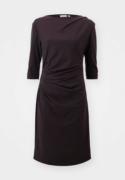 Robe noire en tissu doux avec un col bateau, des manches trois-quarts et des détails froncés à la taille, longueur au-dessus du genou.