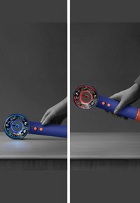 Dispositivo portatile con corpo cilindrico blu, parte frontale circolare con luci blu e rosse e pulsanti arancioni. Impugnatura testurizzata alla base.