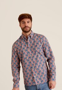 Overhemd met knopen, met een roze achtergrond en een blauw palmbomenpatroon. Gemaakt van lichtgewicht stof, met een kraag en lange mouwen.