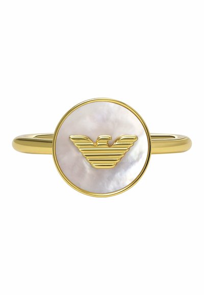 Goldfarbener Ring mit einem runden, schimmernden Perlmuttzentrum, das mit einem erhabenen, gestreiften Adlerlogo versehen ist. Glatter Ring, minimalistisches Design.