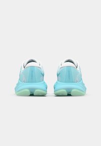 Light blue athletic shoes with mesh and textile upper, white accents, padded collar, and green rubber sole, viewed from the back.