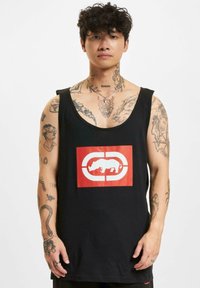 Black sleeveless tank top featuring a central red graphic with a white rhinoceros design. Cotton material with a relaxed fit.
