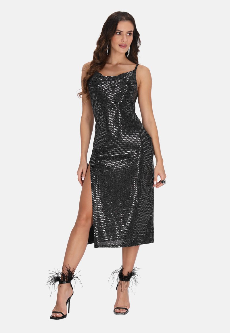Robe en sequins noirs avec un col bénitier, une fente haute sur la cuisse et des bretelles spaghetti réglables. Associée à des talons à bride cheville en plumes noires.
