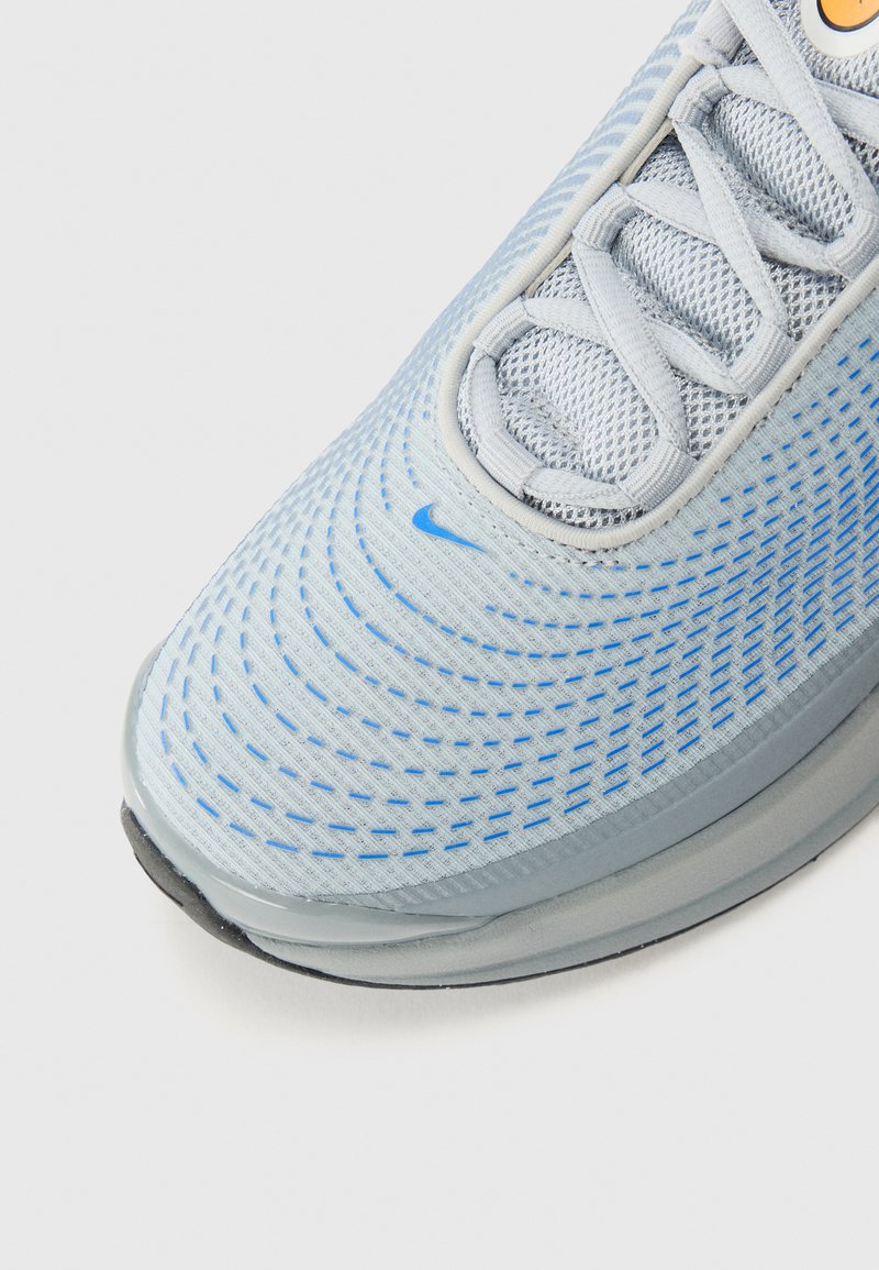 Baskets de sport bleu clair avec une tige en maille texturée, un système de laçage et de subtils motifs ondulés. Semelle extérieure en caoutchouc pour l'adhérence.