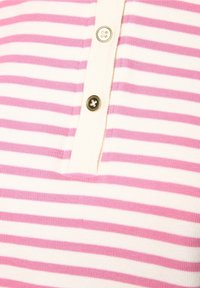 Bavlněná polo košile v krémové barvě s horizontálními růžovými pruhy, s knoflíkovou légou se zlatými a černými knoflíky. Měkká textura.