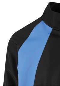 Sort og blå sports top med høj krave, glat stof og en diagonal blå panel på skulderen for kontrast og designdetalje.