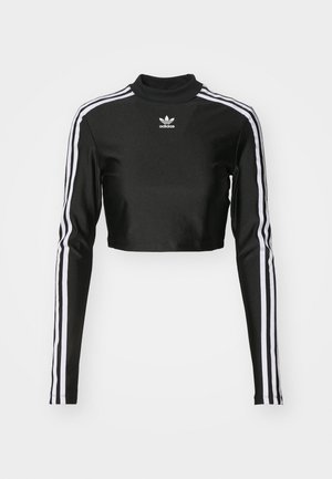 Black cropped long-sleeve top made of smooth fabric, featuring white three-stripe detailing along the sleeves and a high neckline.
