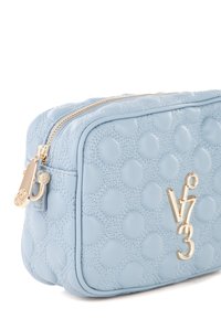 Beauty case in pelle azzurro chiaro con una texture a pois, zip dorata e dettaglio del logo con "V3". Forma rettangolare compatta.