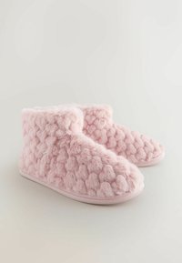 Lyserøde pelsede hjemmesko med en tekstureret, puffet overflade og blødt foer, der har en lav ankeludforming og flade såler til indendørs brug.