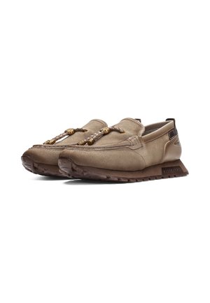 Paire de mocassins en daim beige avec lacets en cuir tressés et perles métalliques décoratives, semelles épaisses en caoutchouc marron et détails cousus.