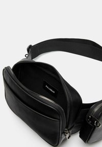 Svart bälteväska i faux läder med ett zippert huvudfack och en mindre sidficka. Utrustad med ett textilband och varumärkesetikett inuti.