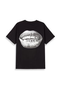 Camiseta negra con un gran gráfico de labios que muestran dientes adornados con grillz de plata, hecha de algodón, con un corte relajado y mangas cortas.