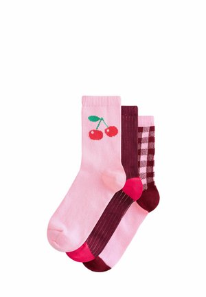 Tre par strumpor: ett par rosa med röda körsbär, ett par i hel mörkröd färg och ett par med rosa och mörkröda rutmönster. Blandad bomullsmaterial.