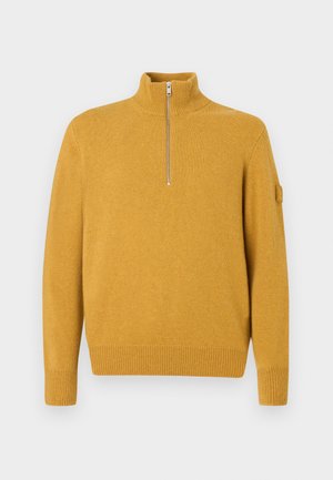 Pull jaune moutarde avec un col haut et une fermeture éclair argentée. Présente des poignets et un ourlet côtelés, fabriqué à partir d'un matériau texturé doux.