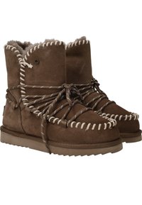 Bruine suède laarzen met een luxe interieur, voorzien van een uniek veters ontwerp, contrasterende witte stiksels en een dikke, gestructureerde zool.