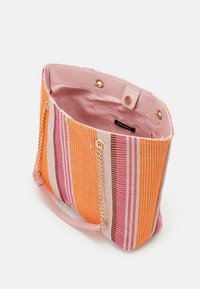 Torba typu tote w paski z pomarańczowym, różowym i fioletowym tkanym materiałem na zewnątrz, różowym materiałowym wnętrzem oraz łańcuszkowym akcentem na rączkach.