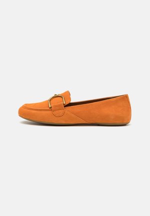 Mocasines de ante naranja para mujer con punta redondeada, suela baja y plana, y detalle de hebilla dorada en la parte superior.