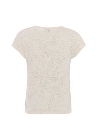 T-shirt beige clair avec un motif texturé subtil, manches courtes type casquette et encolure arrondie. Coupe décontractée sans éléments apparents en métal.