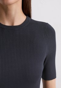 Navy ribbed t-shirt with short sleeves, featuring a round neckline and a soft, stretchy fabric that enhances comfort and fit.