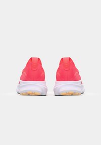 Pink running shoes with a breathable upper, white midsole, and textured rubber outsole. Includes pull tabs at the heel for easy wearing.