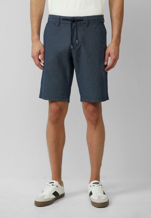 Marineblaue Shorts aus strukturiertem Stoff mit Kordelzug an der Taille, seitlichen Taschen und geradem Schnitt, kombiniert mit weißen Sneakers.