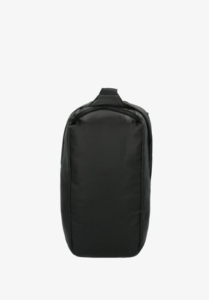 Mochila negra de forma rectangular, hecha de material duradero, con un asa superior y una sutil marca en la parte frontal. Textura suave.