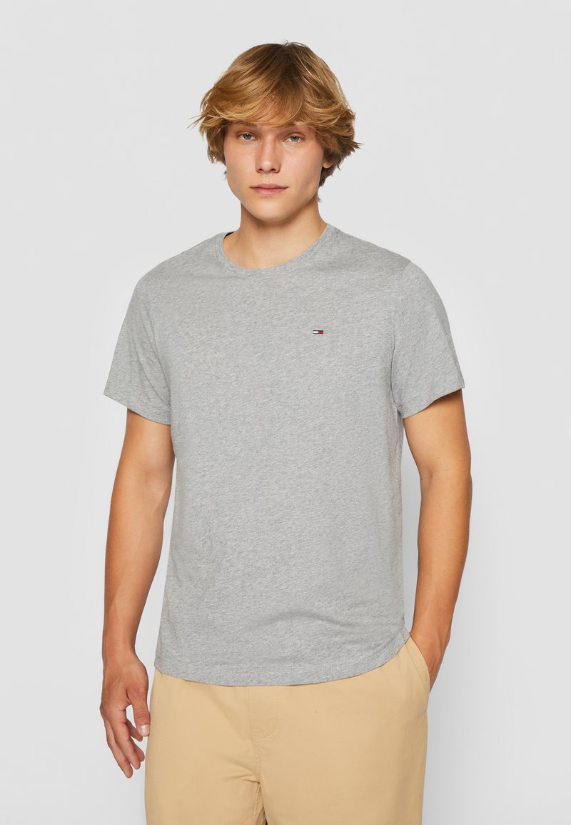Grå bomullen t-shirt med korta ärmar och rundad hals. Har en liten logotyp på vänster bröstområde, slät textur och avslappnad passform.