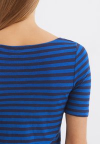 Gestreift in Blau und Marineblau, kurzärmliges Oberteil mit weiter Ausschnitt, gerippter Textur und glattem Stoff, der ein einfaches und lässiges Design zeigt.