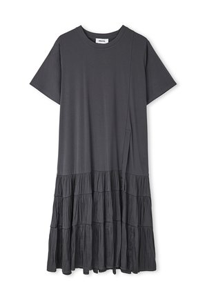 Vestido gris con mangas cortas, dobladillo en capas con volantes, textura suave y silueta relajada. La tela parece ligera y fluida.