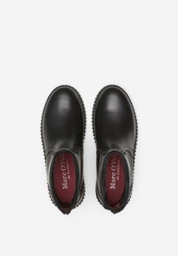 Bottines en cuir noir avec un bout rond, une semelle en caoutchouc texturé et un intérieur rouge. Équipées de côtés élastiques pour un enfilage facile.