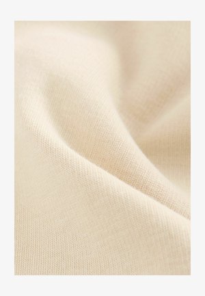 Šviesiai smėlio spalvos audinys su smulkiu tekstūriniu kojininiu raštu; minkšta, lygus paviršius, kuris švelniai krenta, pabrėždamas savo tempimo savybes.