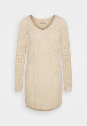 Maglione beige a maglia con scollo a V, maniche lunghe e polsini a costine; presenta una trama a trama larga e un orlo posteriore leggermente più lungo.