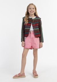 Spalvota austinė striukė su vertikaliomis juostelėmis, derinama su šviesiai rožiniais džinsiniais šortais ir rožiniais pintais sandalais. Pasiūtas paprastas baltas marškinėliai po juo.