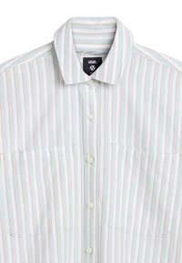 Camicia azzurra chiaro a maniche corte con righe verticali bianche e pesco, due taschini sul petto e chiusura con bottoni. Presenta un colletto.
