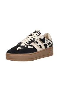 Black and white cow print sneaker with suede and leather materials, featuring a beige rubber sole and beige laces. Distinctive design details.